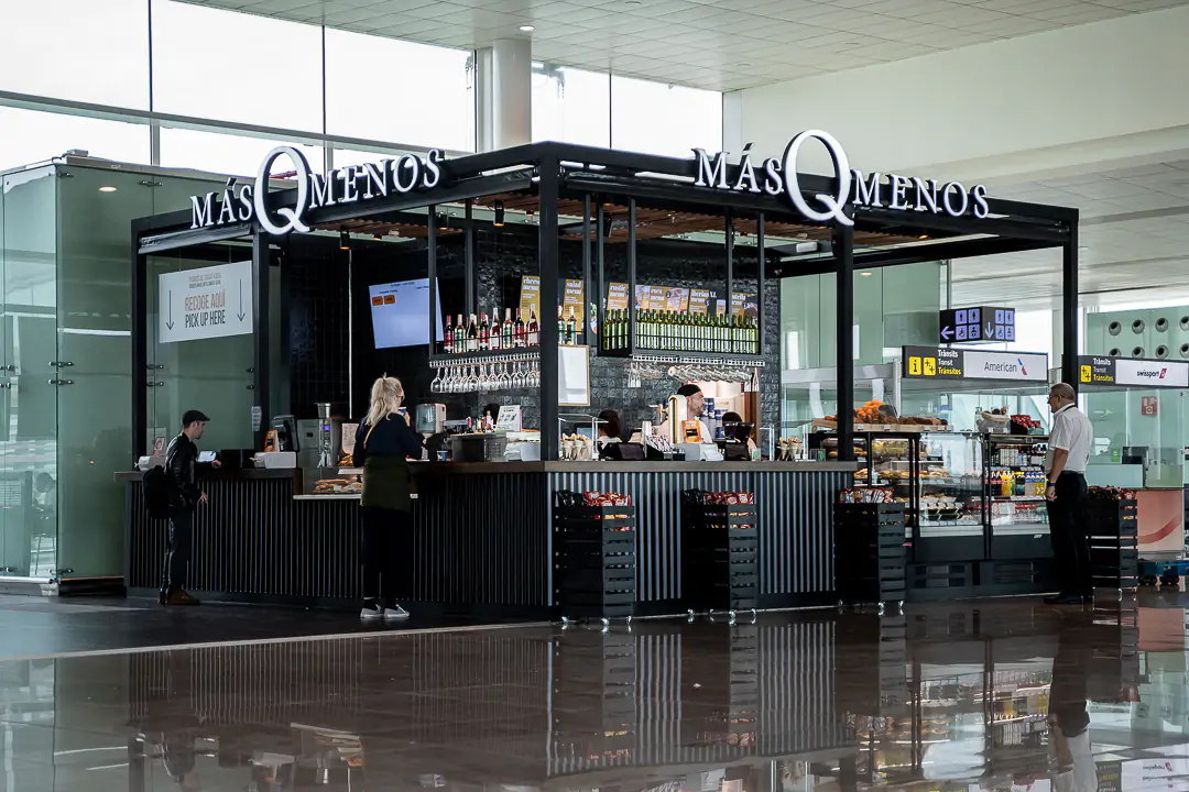 Quiosco MásQMenos en aeropuerto con barra y vitrinas.